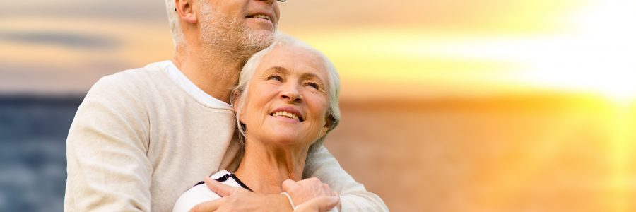 old age, tourism, travel and people concept - happy senior couple over sunset background